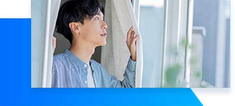 カーテンを開けている男性の画像