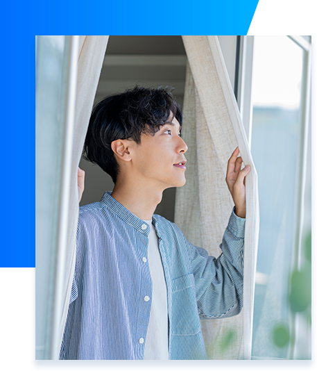 カーテンを開けている男性の画像